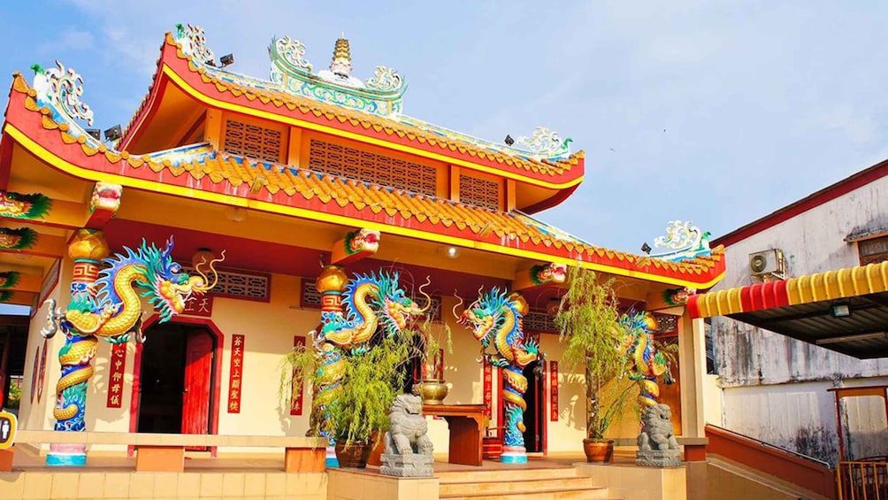 A traditional Chinese temple with ornate dragon decorations and a multi-tiered roof. 1