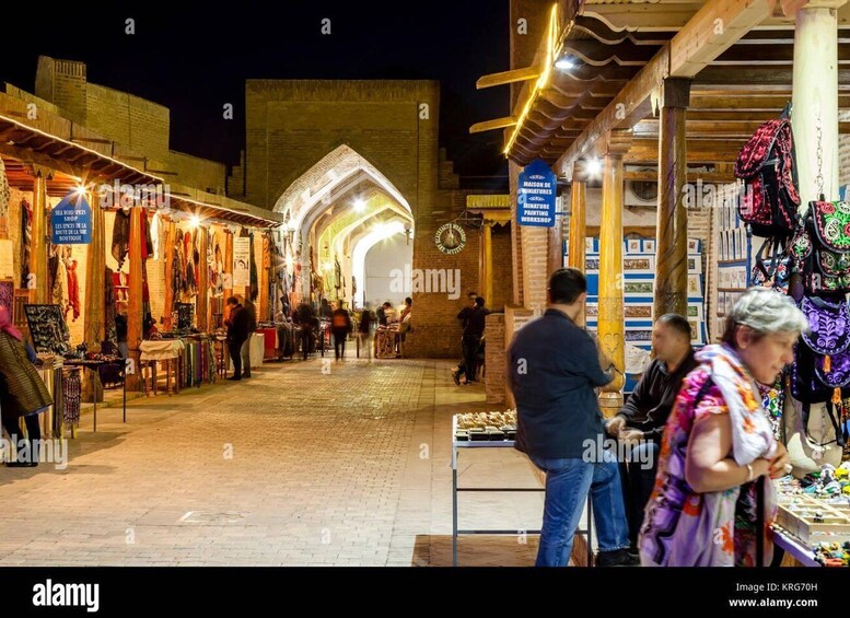 A nighttime market with stalls selling textiles and crafts. 2