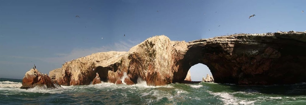 A coastal rock formation with a natural arch over the sea. 5