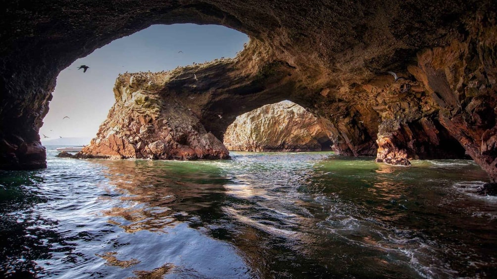 A natural rock arch over a body of water. 1