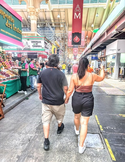 A bustling market street with people walking, vendors selling fruits, and various shops. 3