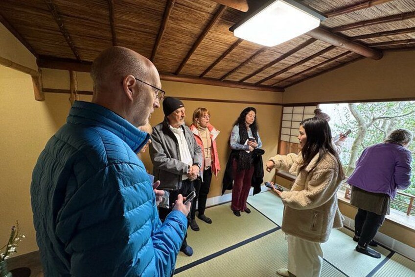 A group of people in a traditional Japanese room with tatami flooring and a wooden ceiling. 2