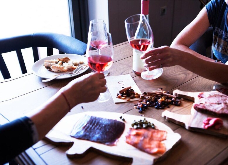 A wooden table with food and wine glasses. 1
