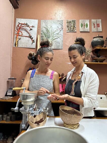 Two people in a kitchen preparing food, with various kitchen utensils and a blender visible. 5