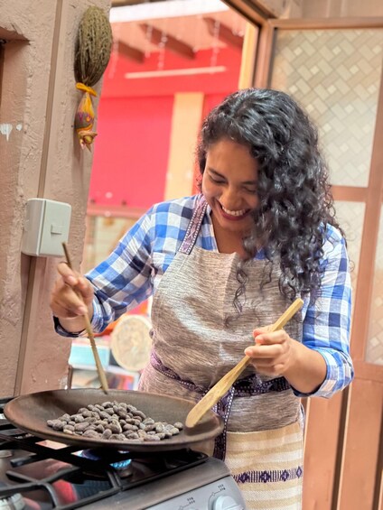 A person cooking with a pan on a stove. 2