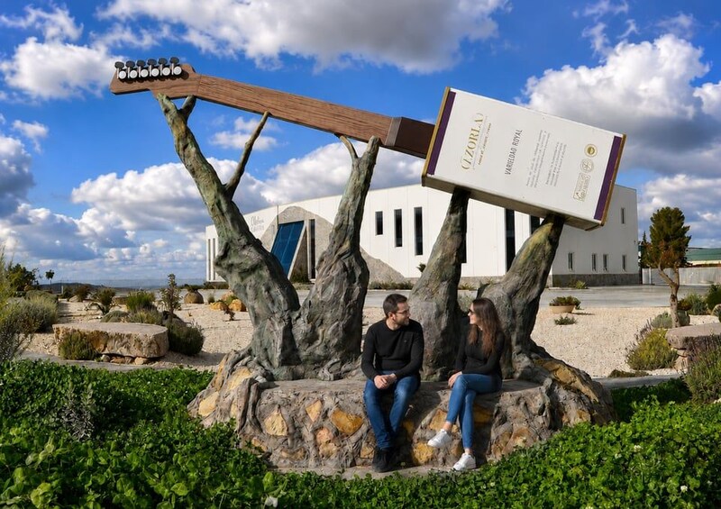 Two people sitting on a rock formation with a guitar and a box in the background. 2
