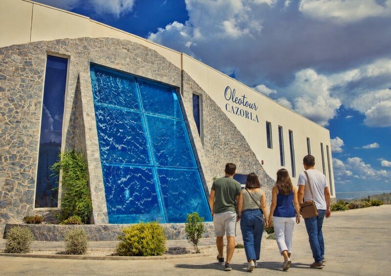 A building with a blue glass facade and the name 'Oleotour CAZORLA' on it. 1
