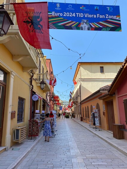 A street with shops and a sign for Euro 2024 TID Viora Fan Zone. 3