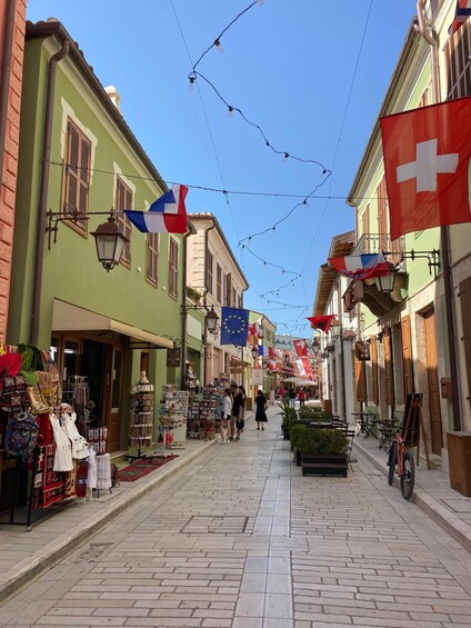 A cobblestone street lined with shops and flags, including the Swiss flag. 5