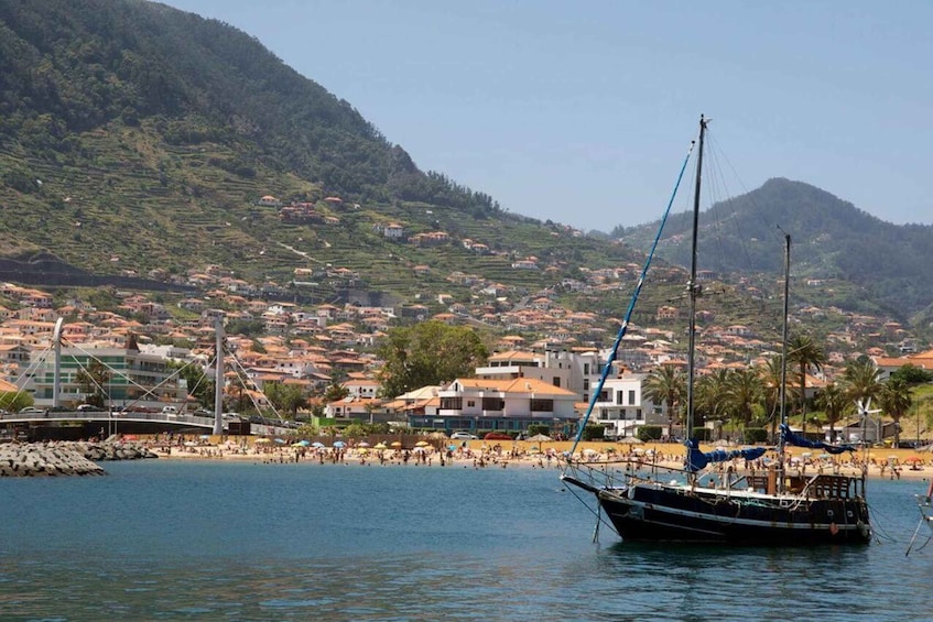 A coastal town with a beach, a fishing boat, and a bridge. 5