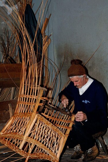 A person weaving a basket from reeds. 2