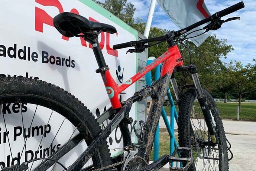A red mountain bike parked in front of a sign with text. 5