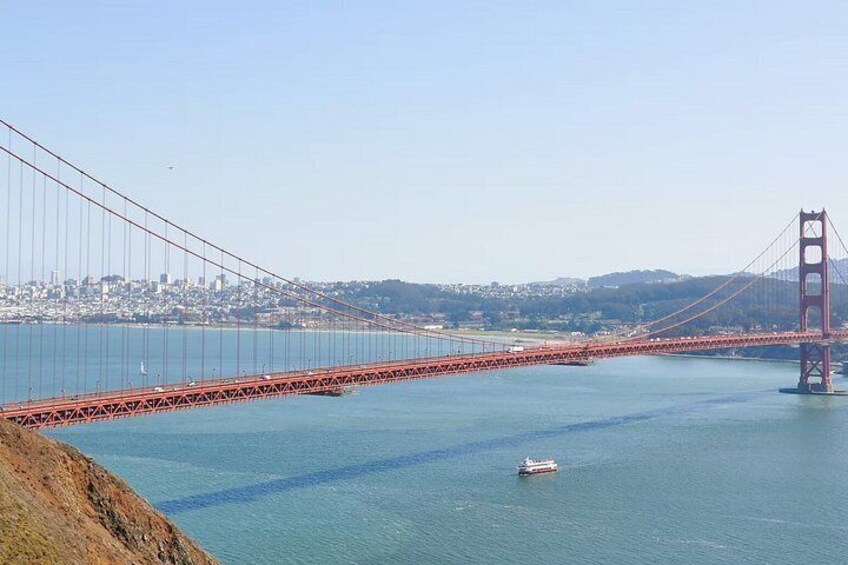 A large suspension bridge spanning a body of water with a cityscape in the background. 5