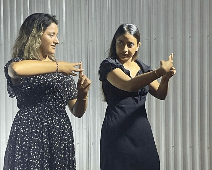 Two women in black dresses performing a dance. 5