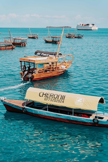 A harbor with several boats, including a large ship in the background and a smaller boat with a canopy labeled 'CHERONII' in the foreground. 3