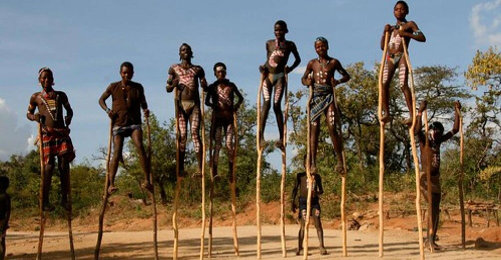 A group of people in traditional attire performing a dance or ritual outdoors. 3