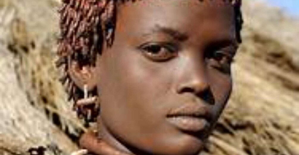 A person with braided hair and a necklace. 2