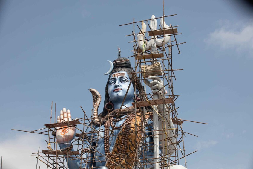A large statue of a deity under construction with scaffolding. 4