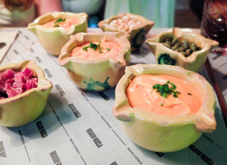 Bowls of food with a creamy sauce and garnished with herbs. 2