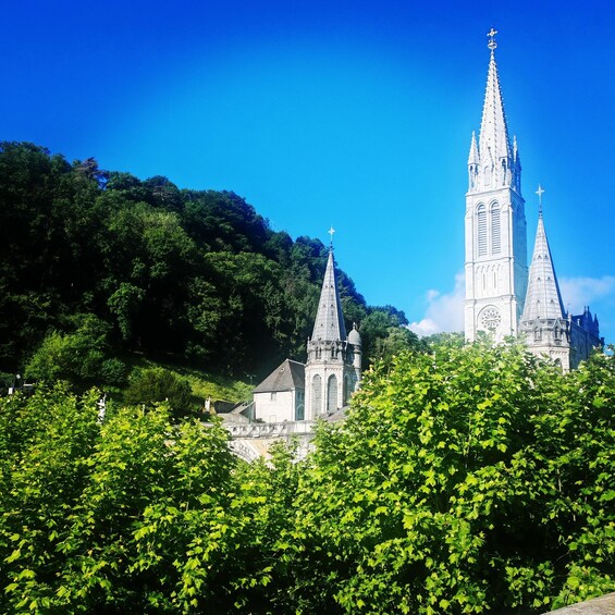 A church with two spires and a forested hill in the background. 3