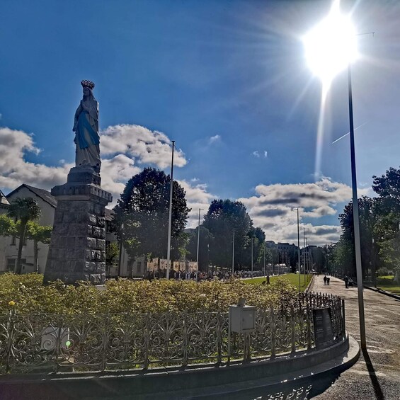 A statue in a park with a clear sky and sunlight. 5