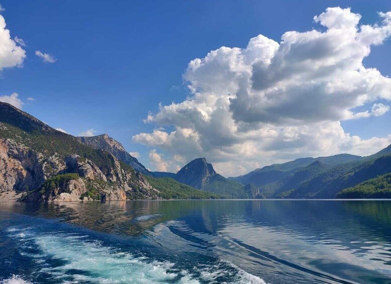 A calm lake surrounded by mountains and a clear sky. 3