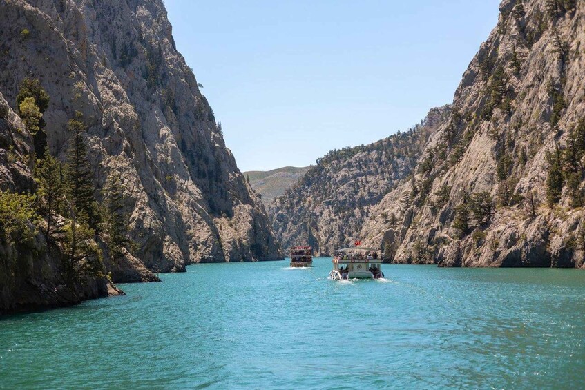 A boat navigating a narrow canyon with steep cliffs on either side. 5