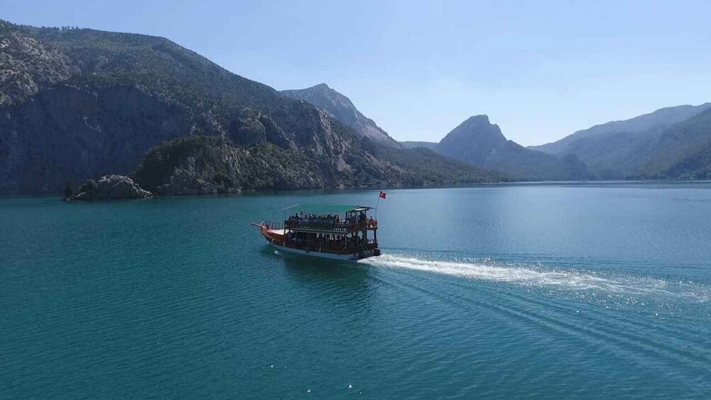 A boat on a calm lake surrounded by mountains. 2