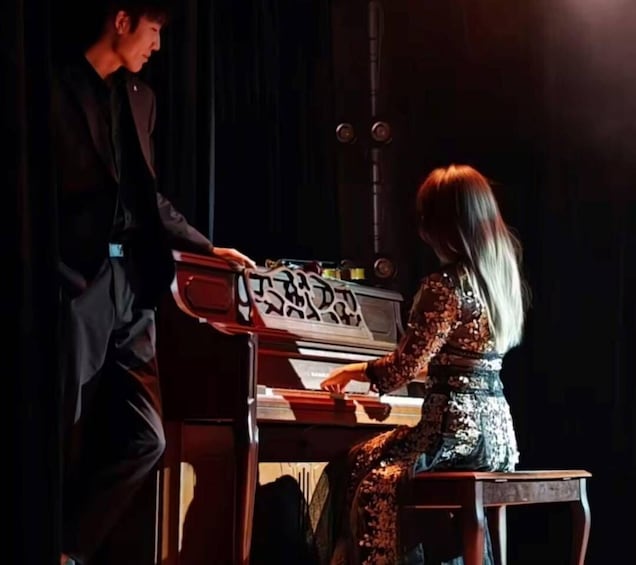 A person playing a piano on stage. 5