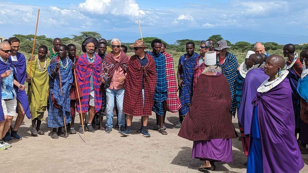 A group of people in traditional attire standing outdoors. 2