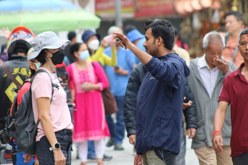 A crowded street with people walking and carrying bags. 5
