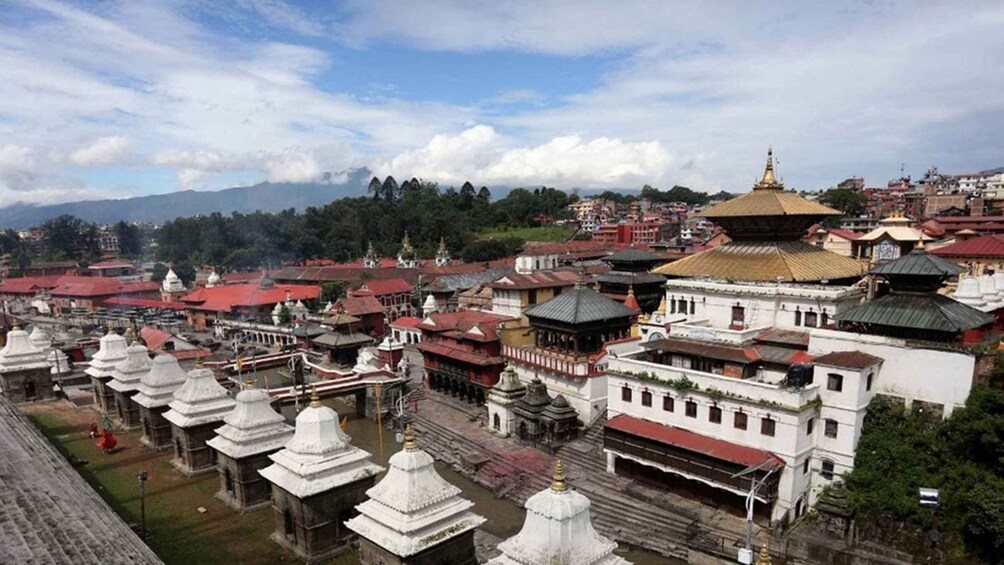 A mountainous town with traditional buildings and a prominent golden-roofed temple. 4