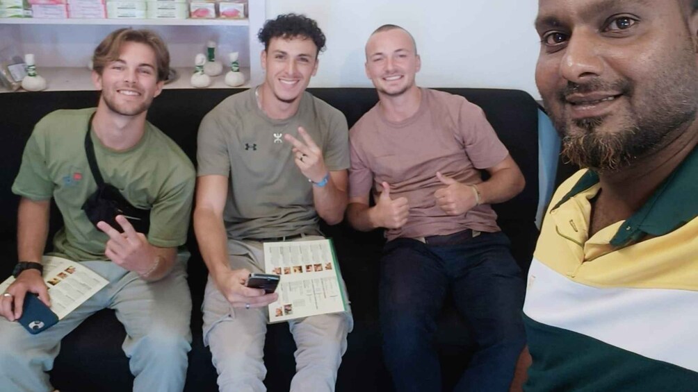 Four people sitting on a couch, holding books and a smartphone. 2