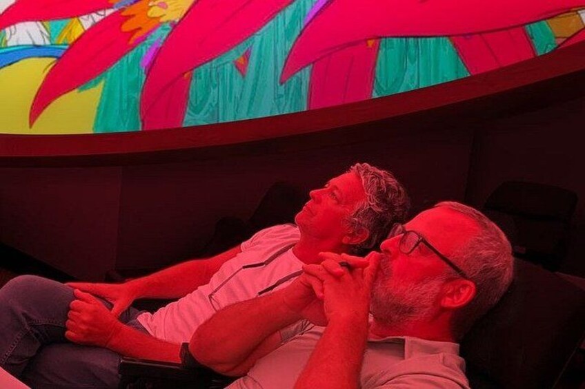 Deux personnes assises sur un canapé, à l'ombre d'un parasol aux couleurs vives. 3