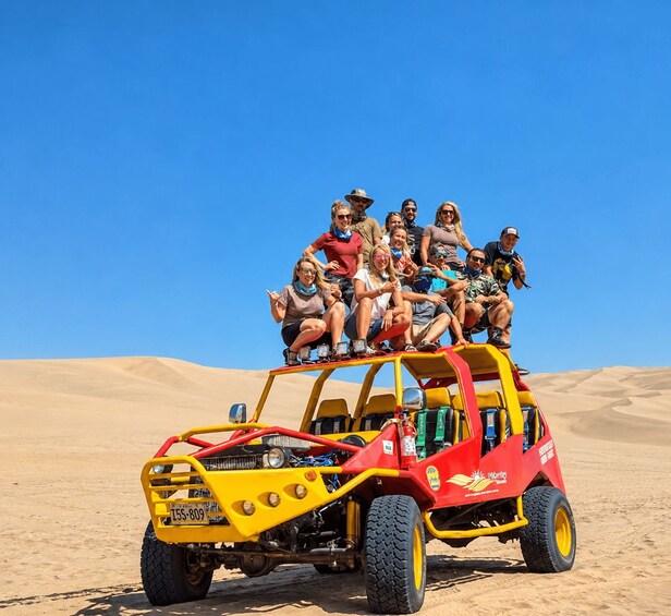 A group of people on a dune buggy in a desert landscape. 1