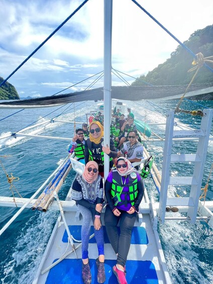 A group of people on a boat with life jackets, surrounded by water and a distant shoreline. 2