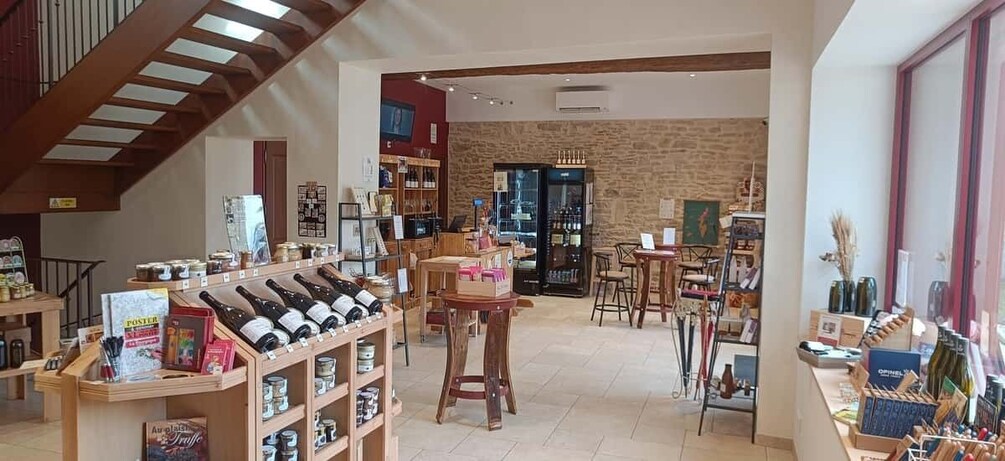 A wine shop with shelves of bottles, a staircase, and a brick wall. 3