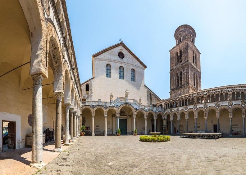 A historic courtyard with a church and a bell tower. 5