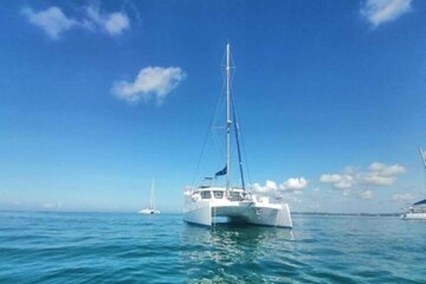 A white sailboat on calm blue waters with a clear sky. 2