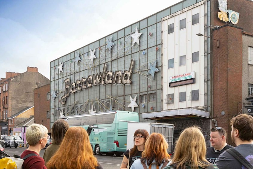 A group of people standing in front of a building with a large sign that reads "Barrowland Leisure Centre." 2