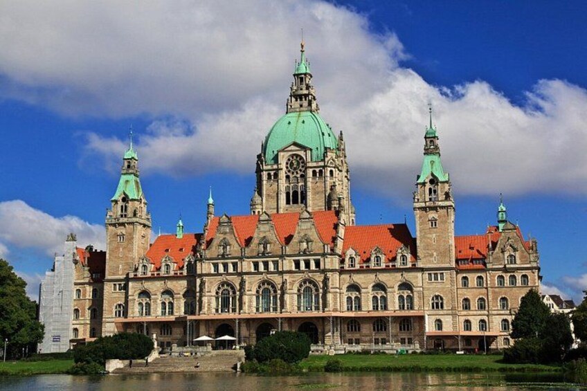 A historic building with a green dome, red roof, and two towers. 5