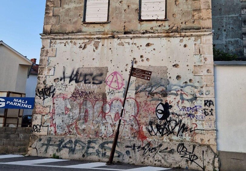 A weathered building with graffiti and a sign for Mali Parking. 2