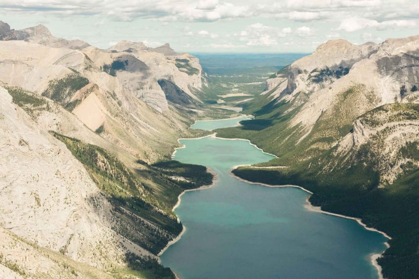 A canyon with a turquoise lake surrounded by rugged mountains. 5