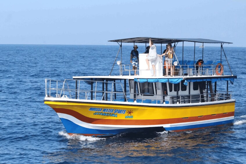 A colorful boat with 'Missa Water Sports' and 'JAYASAYURA' written on it, sailing on the water. 5