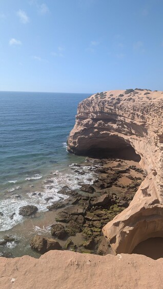 A coastal landscape with a prominent rock formation and the ocean. 2