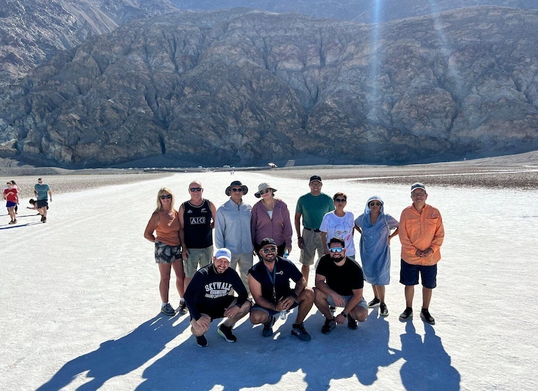 Un groupe de personnes posant sur un paysage enneigé, avec des montagnes en arrière-plan. 3