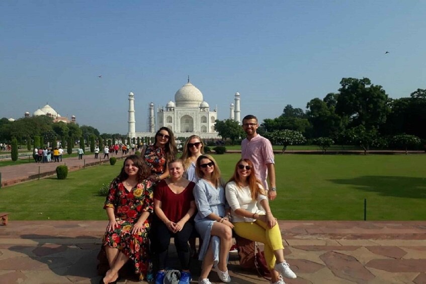 Ryhmä ihmisiä poseeraa Taj Mahalin edessä. 4