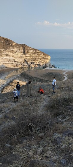 A coastal landscape with rocky terrain and a cliff overlooking the sea. 5