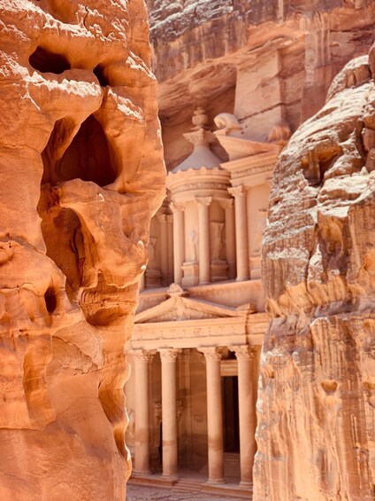 A rock formation with a carved facade and columns. 2