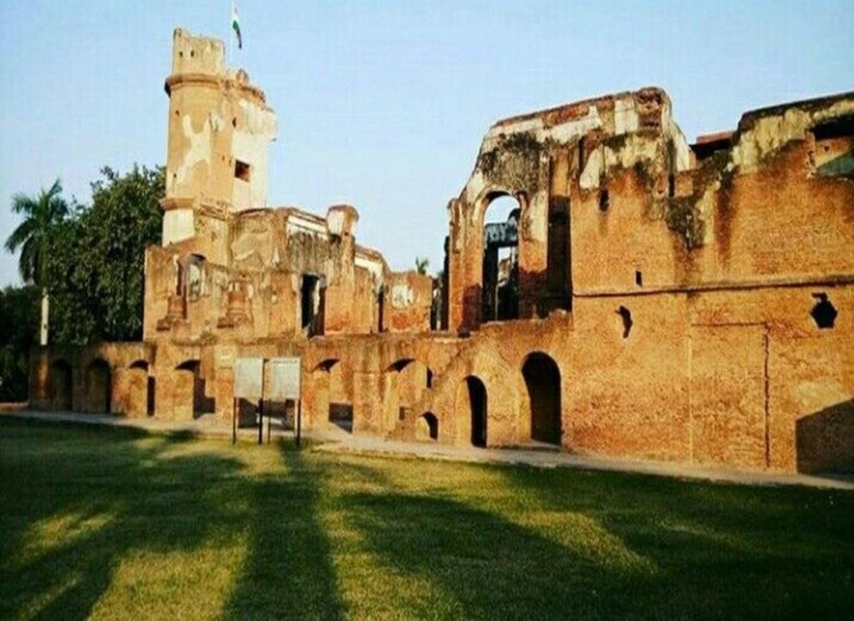 An ancient brick structure with arches and a tower. 3